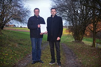 Helmut Kaufmann übergibt die fertige Masterarbeit an Bgm. Franz Penz © Gemeinde Dunkelsteinerwald Helmut Kaufmann übergibt die fertige Masterarbeit an Bgm. Franz Penz © Gemeinde Dunkelsteinerwald